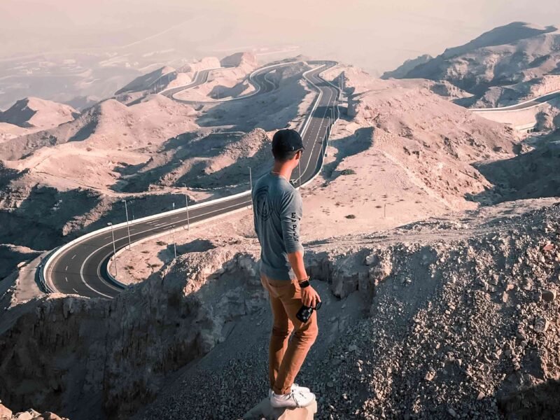 a boy looking jebel hafeet mountains